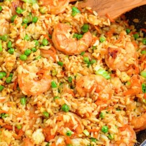 Shrimp fried rice has been cooked in a black skillet and is ready to serve.
