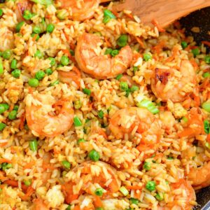 Shrimp fried rice has been cooked in a black skillet and is ready to serve.
