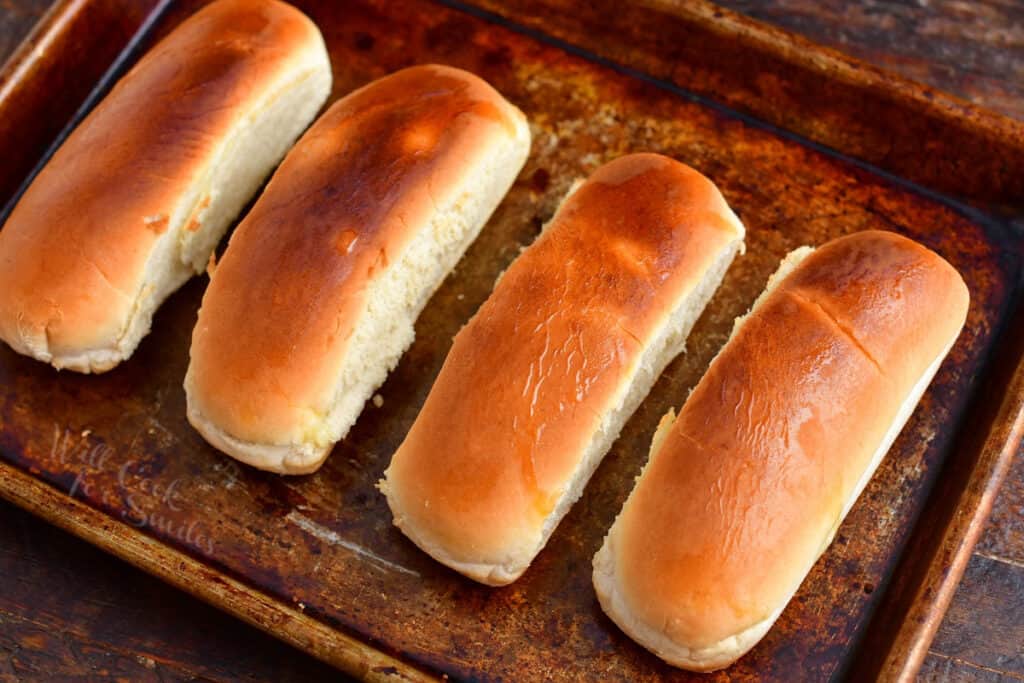 Hot dog buns are browned on a baking sheet.