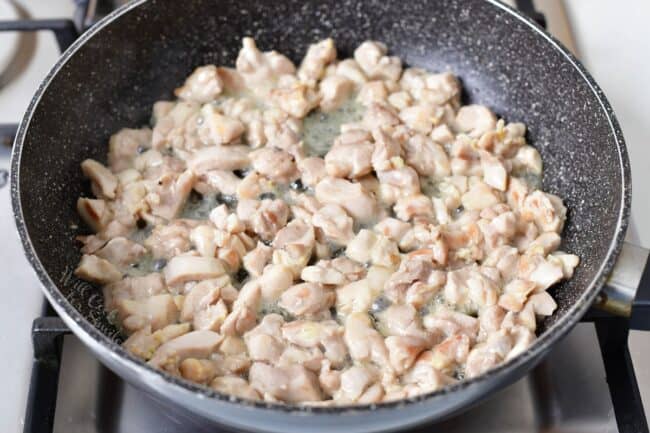 diced chicken thigh meat cooking in a large pan
