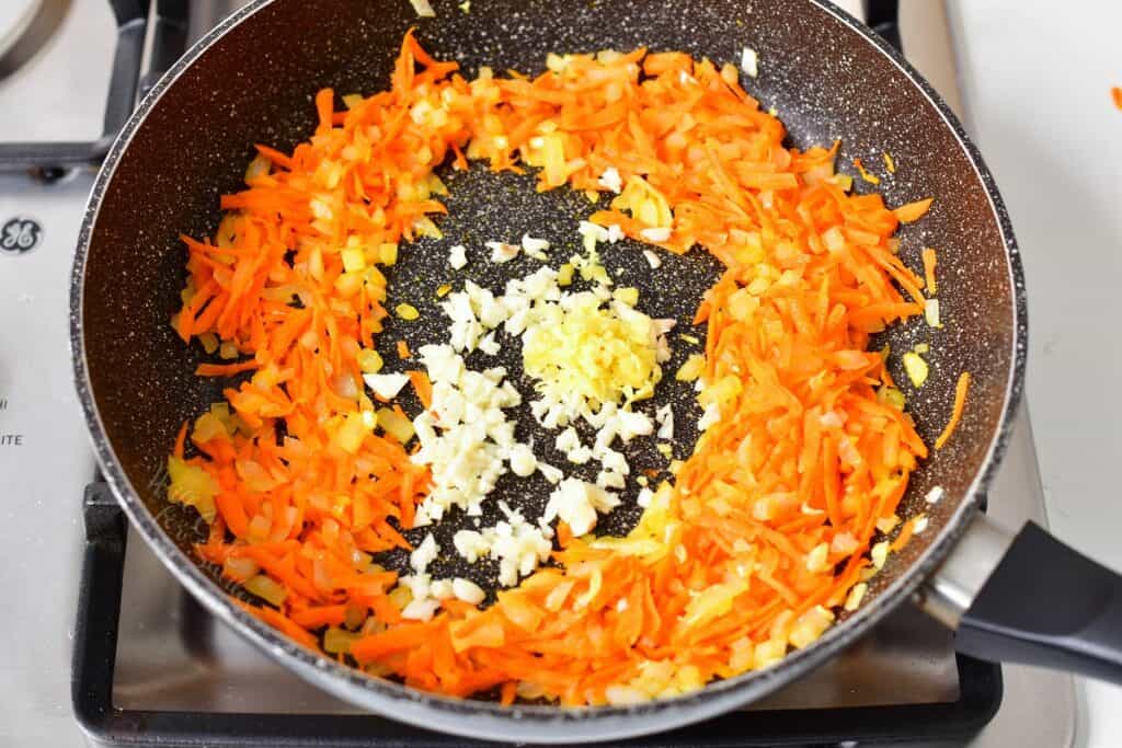 onions and carrots cooking with garlic and ginger in the middle