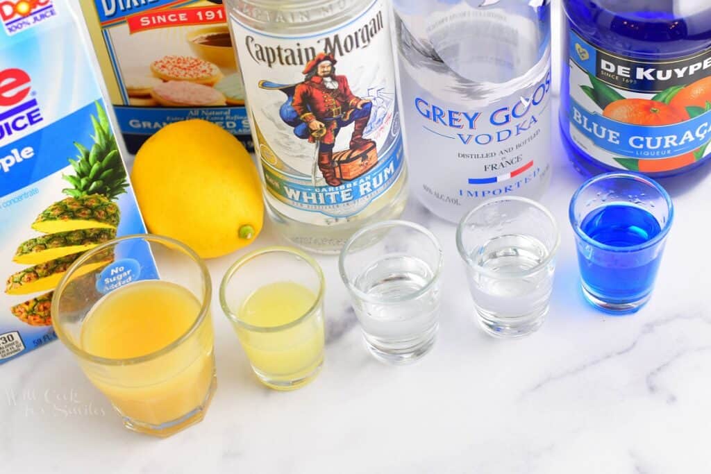 ingredients lined up in small glasses for blue hawaii