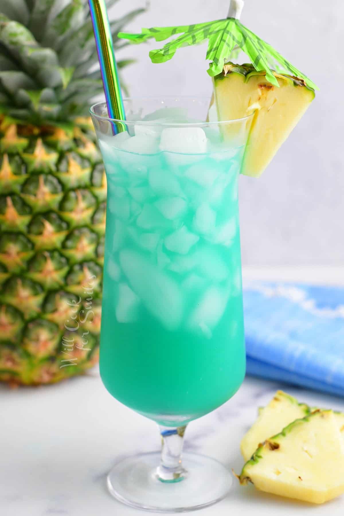 tall hurricane glass filled with blue cocktail