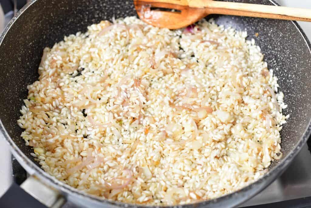 rice sautéing in the pan with shallots