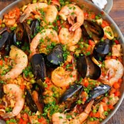 A large pan is filled to the brim with freshly cooked paella.