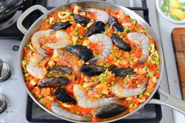 Shrimp and muscles are being cooked together with the paella.