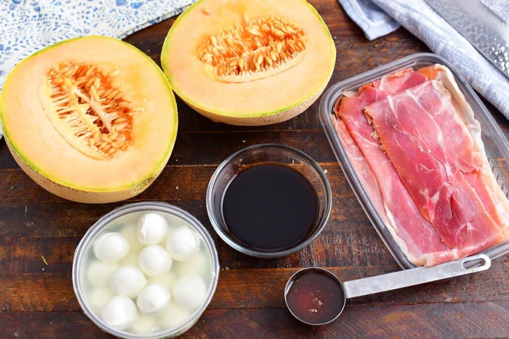 ingredients for prosciutto wrapped melon on a wood board