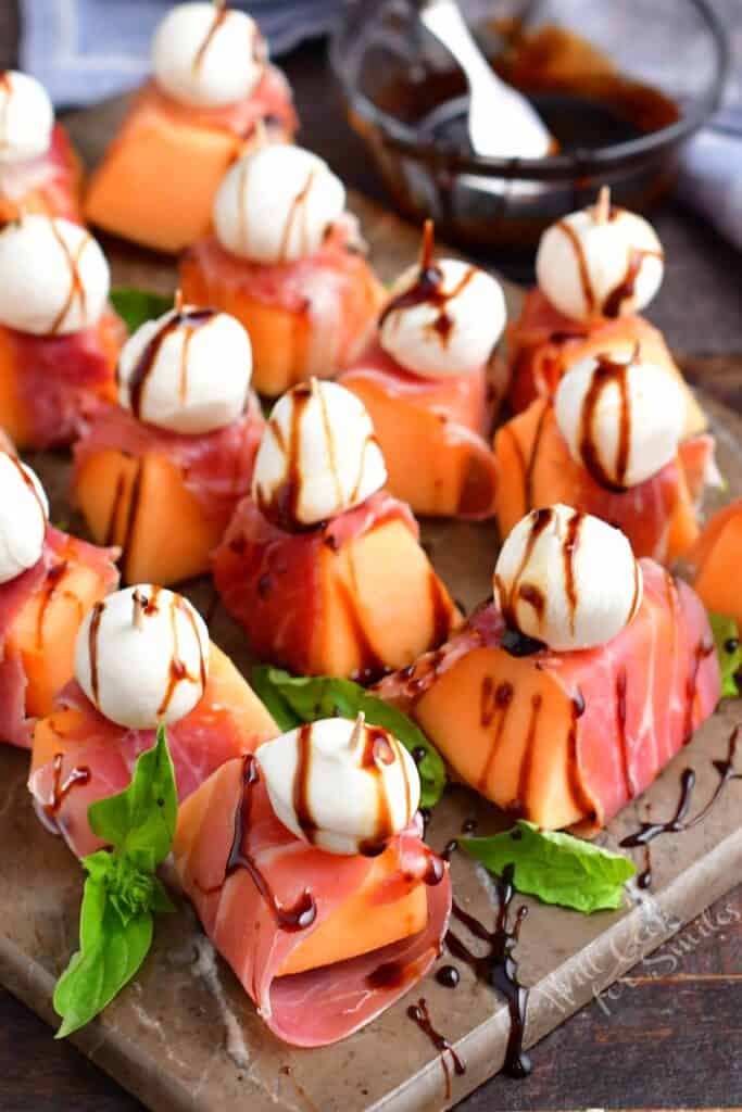 top view of melon wrapped in prosciutto with mozzarella ball and balsamic glaze
