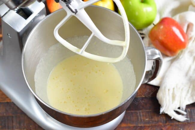 Eggs and sugar are combined in the bottom of an electric mixer bowl.
