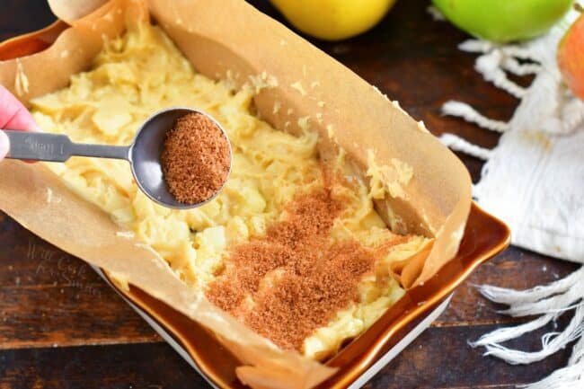 More cinnamon sugar is being topped on the batter.