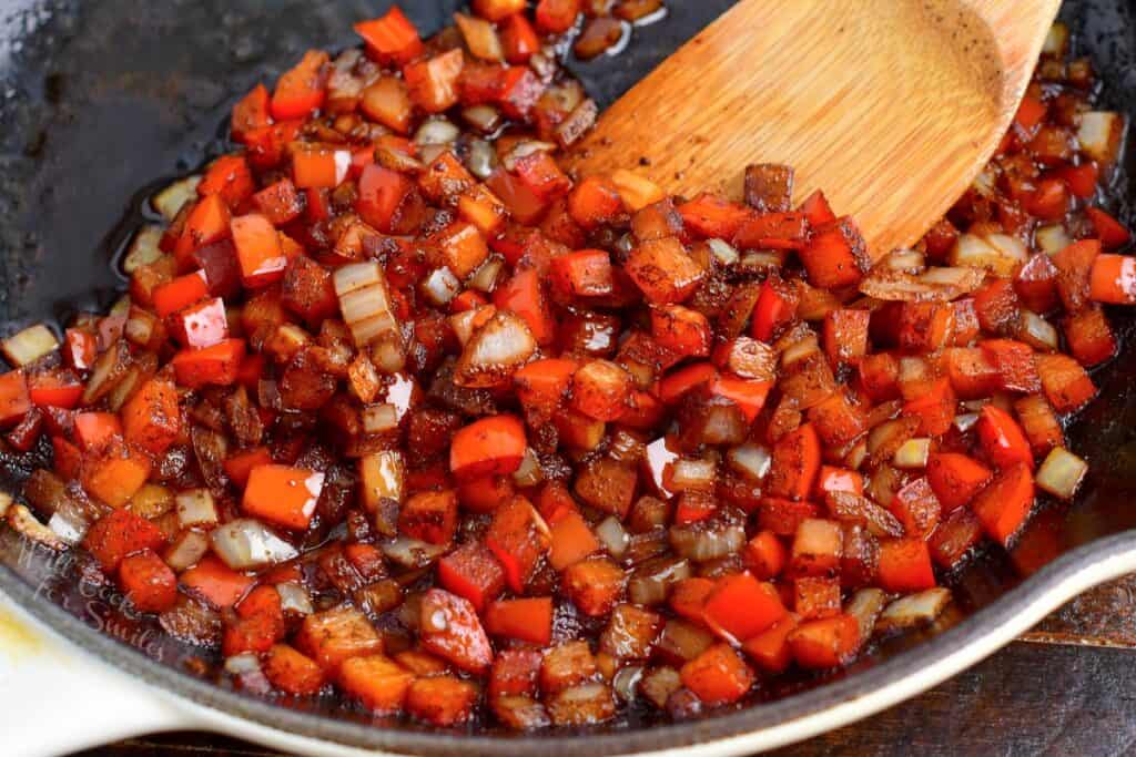 cooked diced onions and peppers in a pan