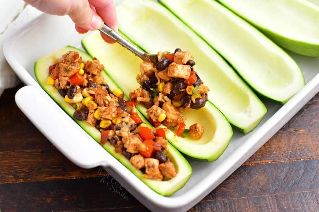 adding southwest chicken filling into the zucchini boats