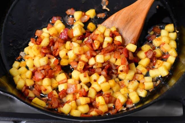 The filling is being cooked in a large black pan.