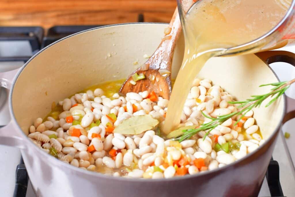 Broth is being poured into a large pot.