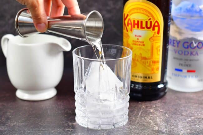 adding vodka to the glass with ice