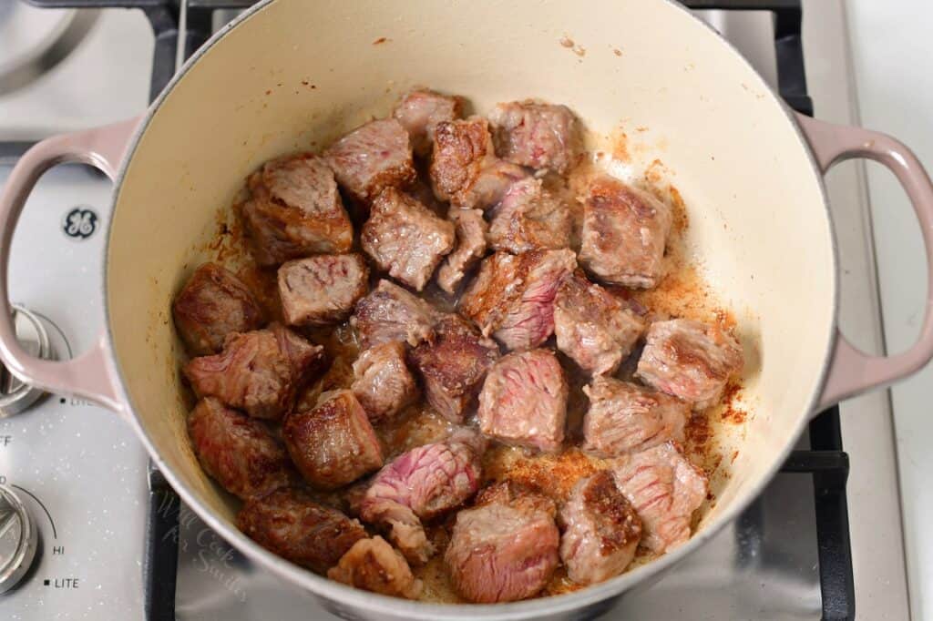 beef pieces seared in a Dutch oven on the stove