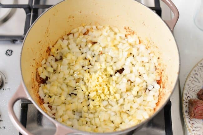 onions and garlic cooking in a Dutch oven