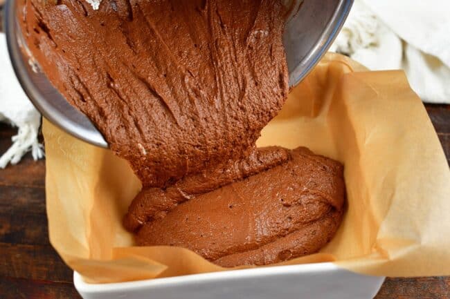 pouring fudge mixture into the dish lined with parchment paper