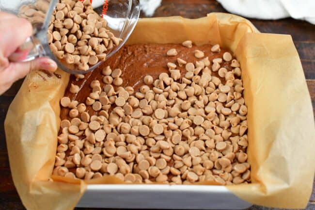 spreading peanut butter chips over the top of fudge