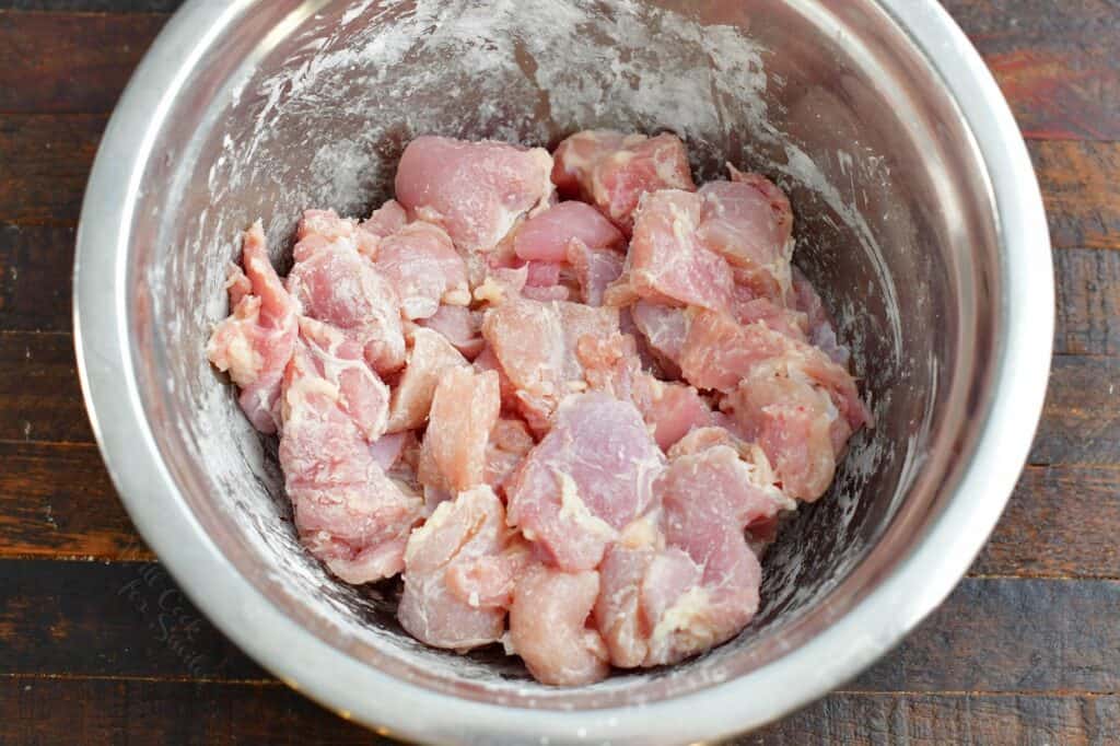 chicken thigh meat tossed in corn starch in a bowl