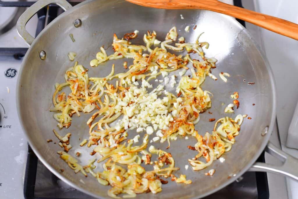 shallots and garlic sautéing in the metal pan