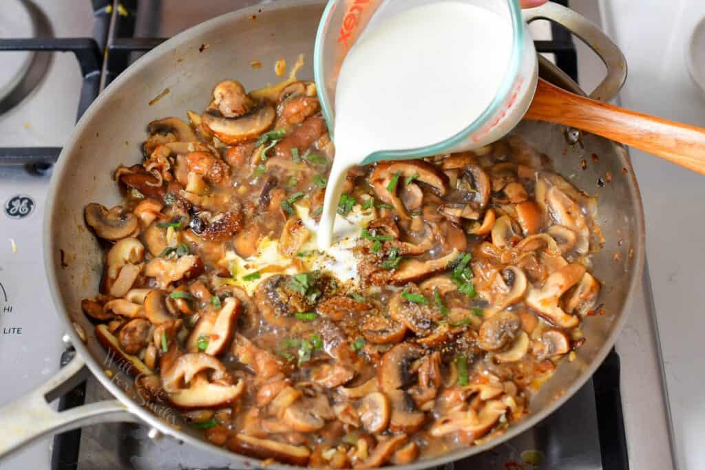 adding cream the the sautéed mushrooms in the pan