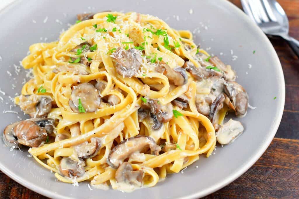 closeup pasta on a plate tossed in creamy mushroom sauce