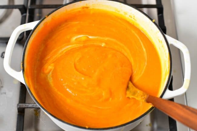 stirring in cream into sweet potato soup