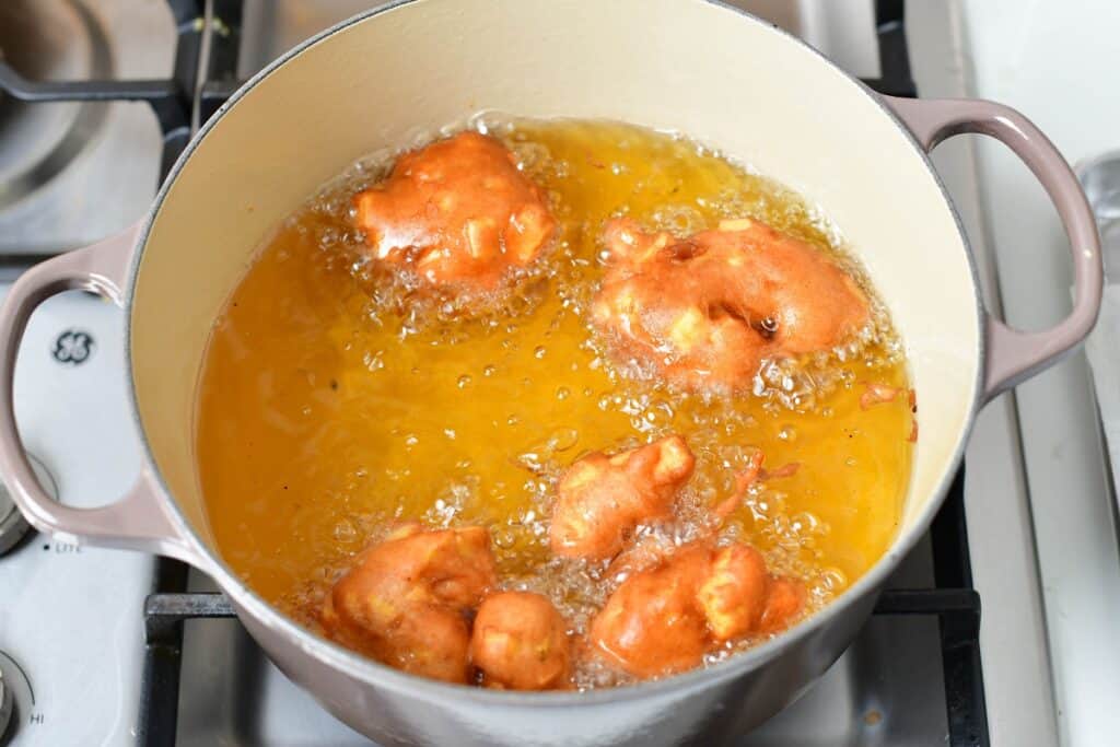 frying the apple fritters in oil in a Dutch oven