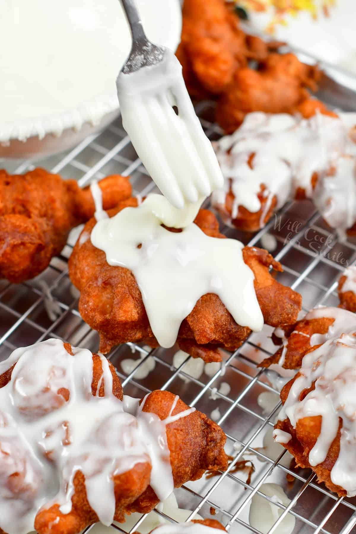 drizzling icing on top of the apple fritter