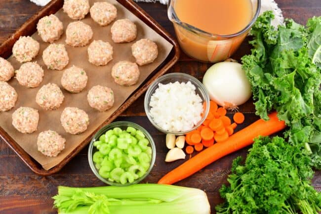 ingredients for chicken meatballs soup on a wooden board
