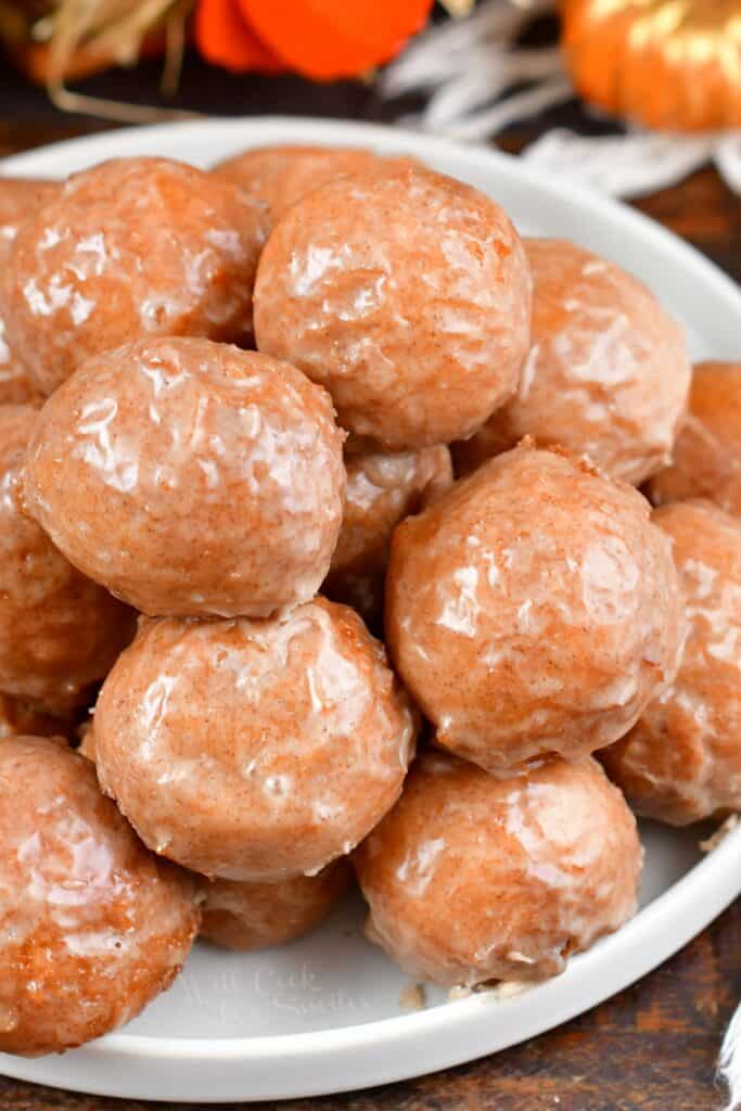 closeup of stacked iced doughnut holes on a plate