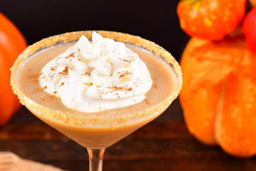 closeup of pumpkin pie martini in a glass with whipped cream on top