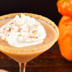 closeup of pumpkin pie martini in a glass with whipped cream on top