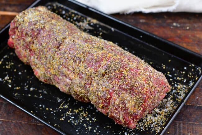 beef tenderloin coated in seasoning on a baking sheet