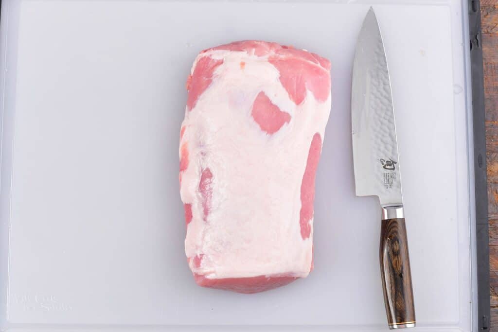 pork loin and a long knife on the cutting board