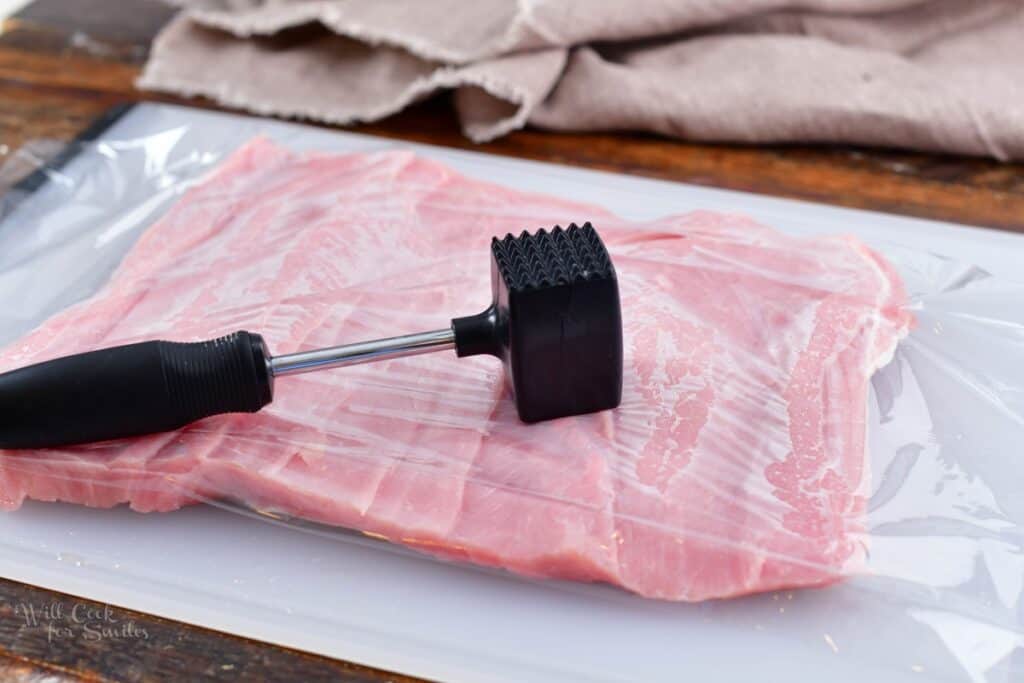 meat tenderizer on top of the butterflied pork loin