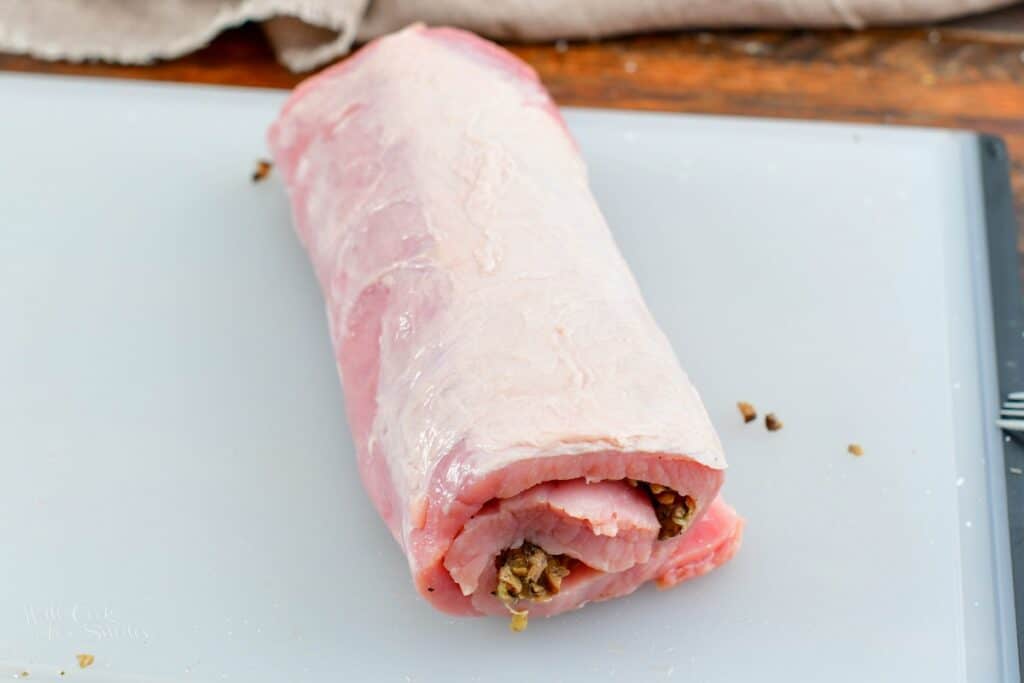rolled up stuffed pork loin in the cutting board