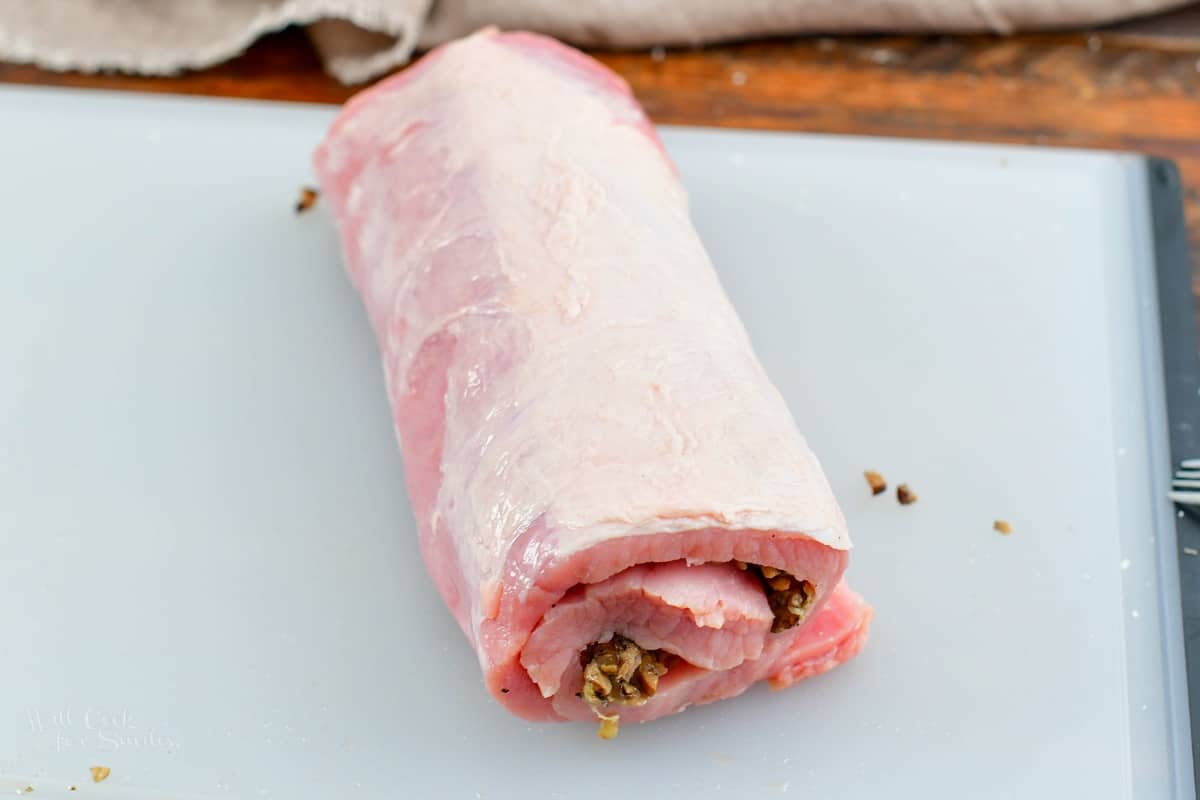 rolled up stuffed pork loin in the cutting board
