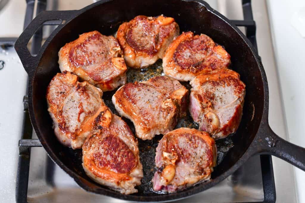lamb chops searing in the skillet
