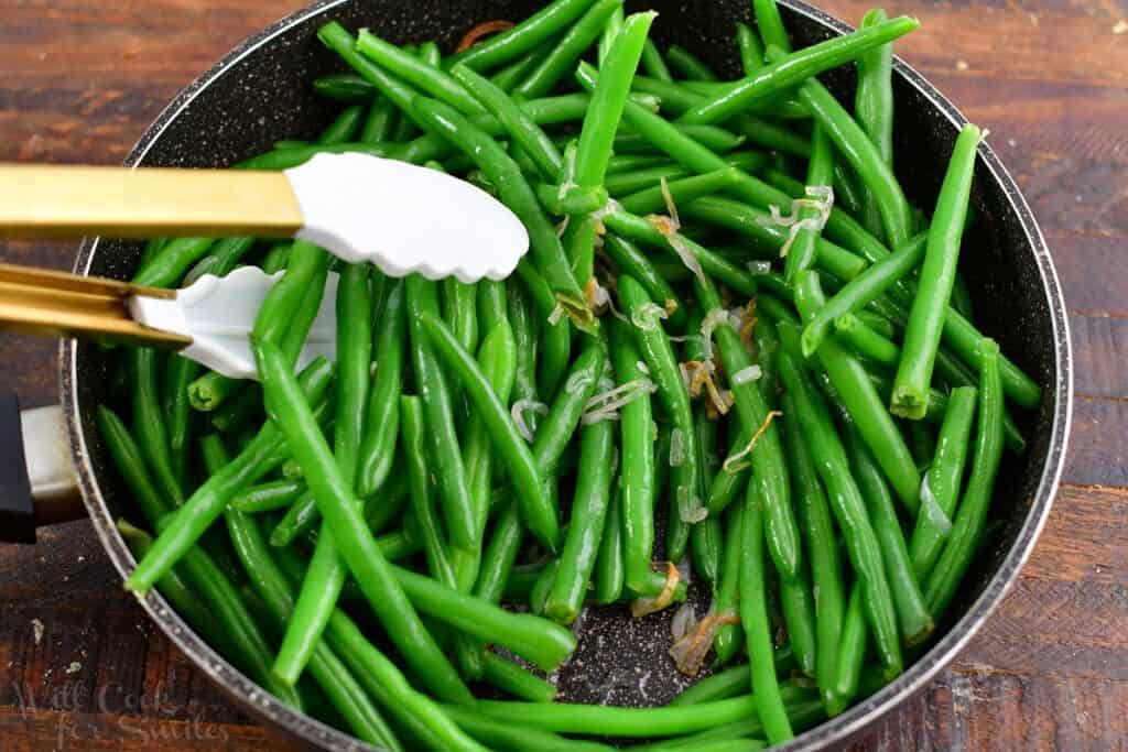 tossing green beans with butter and shallots