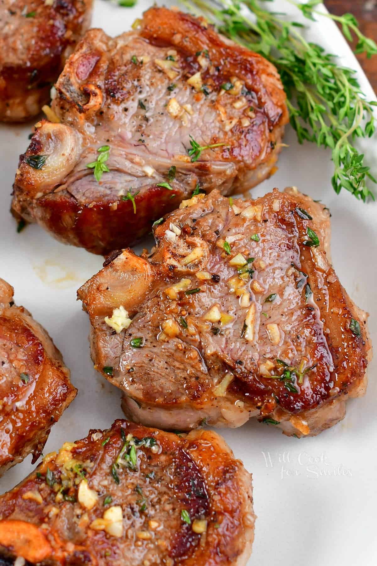 a few seared lamb chops on the plate with thyme.