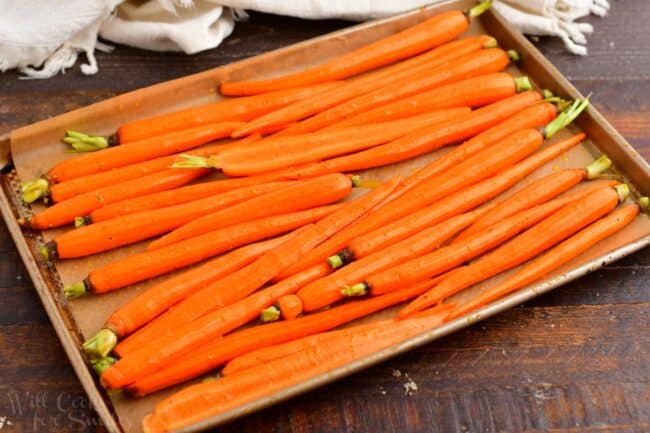 whole carrots on a baking sheet with glaze