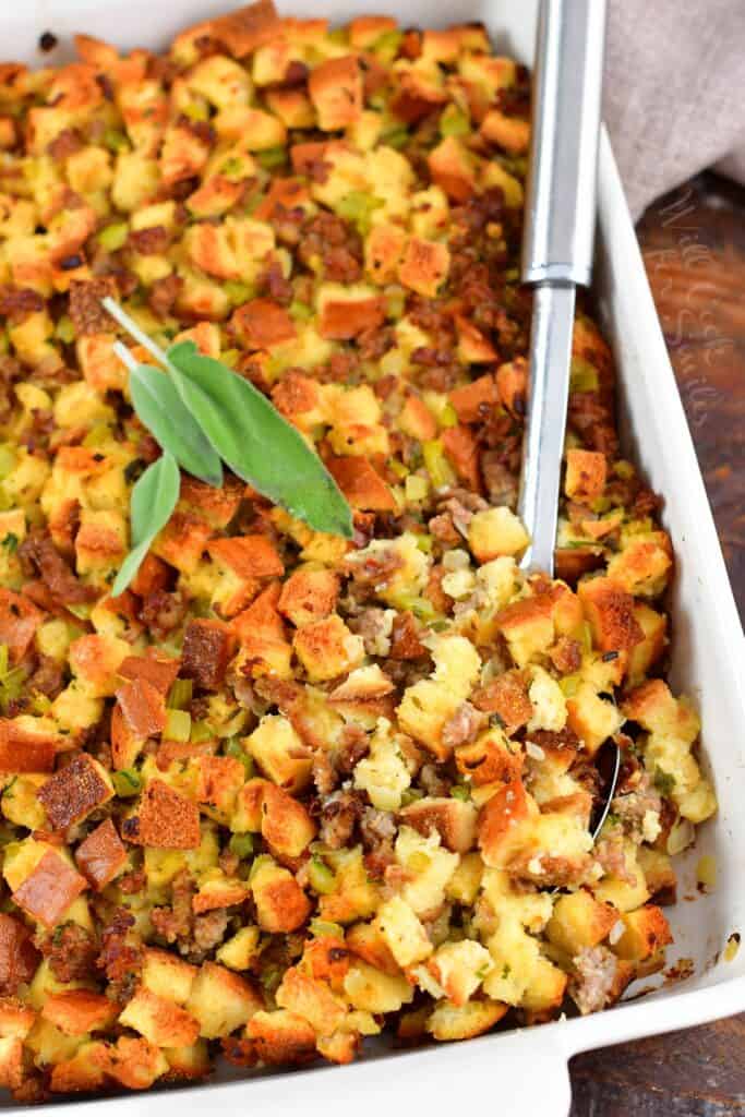 top view of sausage stuffing in a dish with a serving spoon
