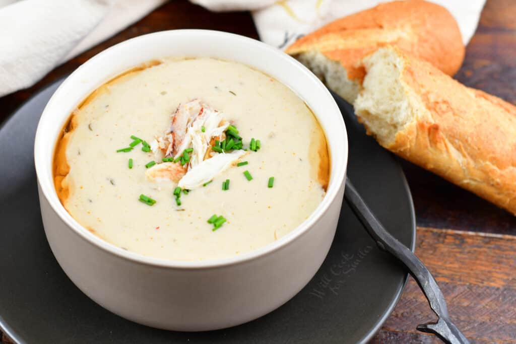 closeup she crab soup in a bowl with bread next to it