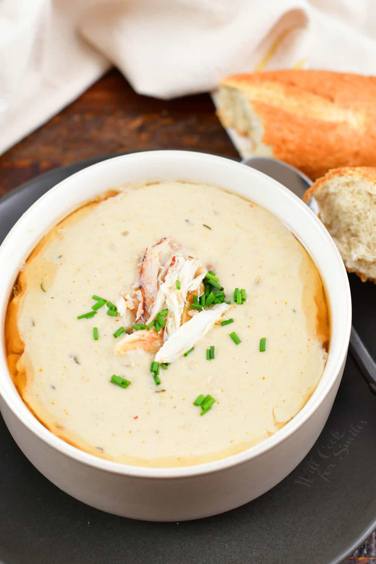 top view of she crab soup in a bowl with bread next to it