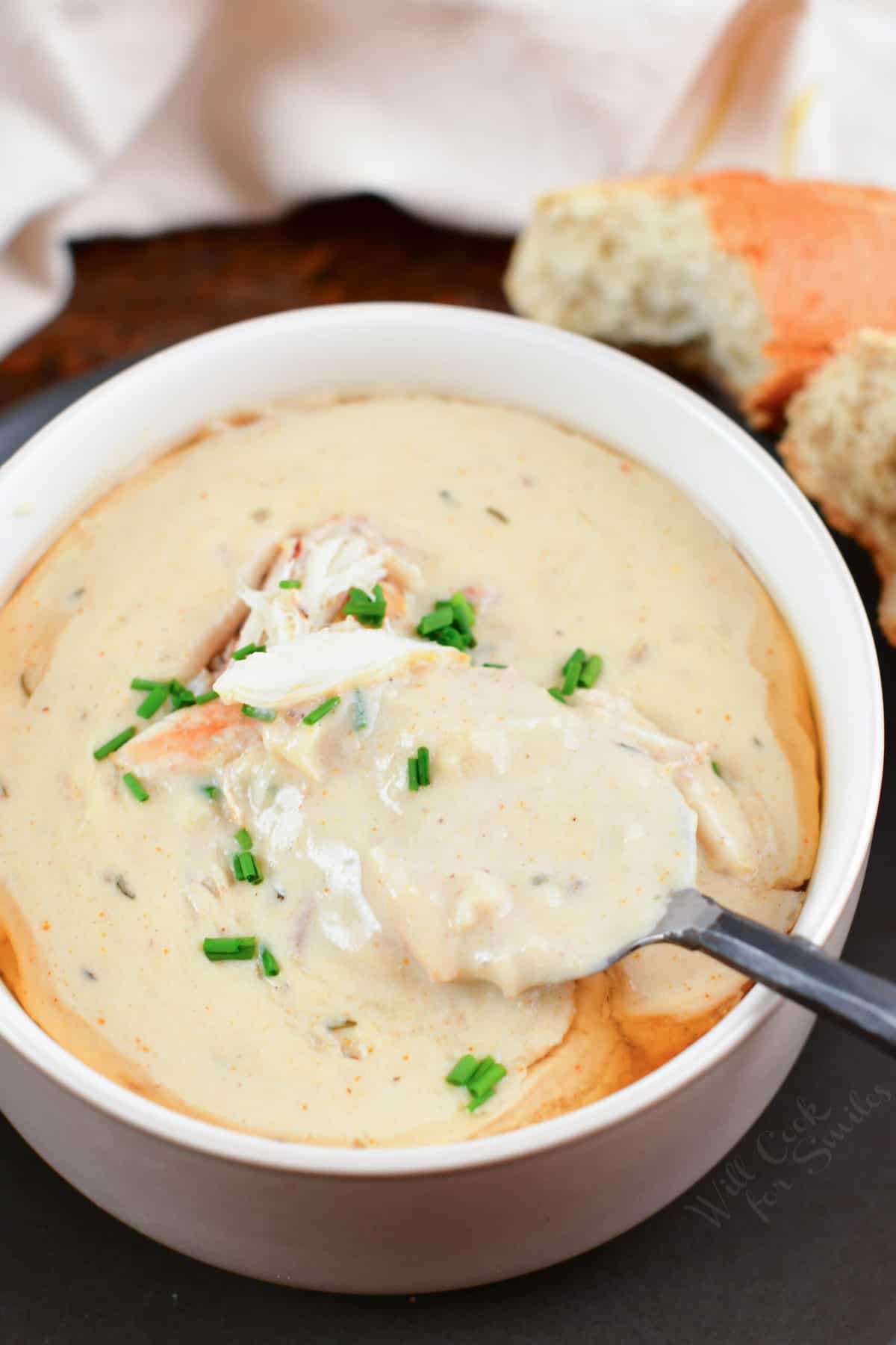 spooning some crab soup out of the bowl