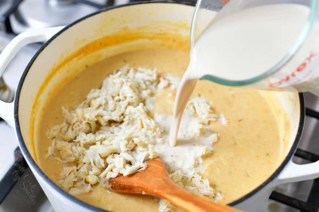adding cream to the soup and more crab meat