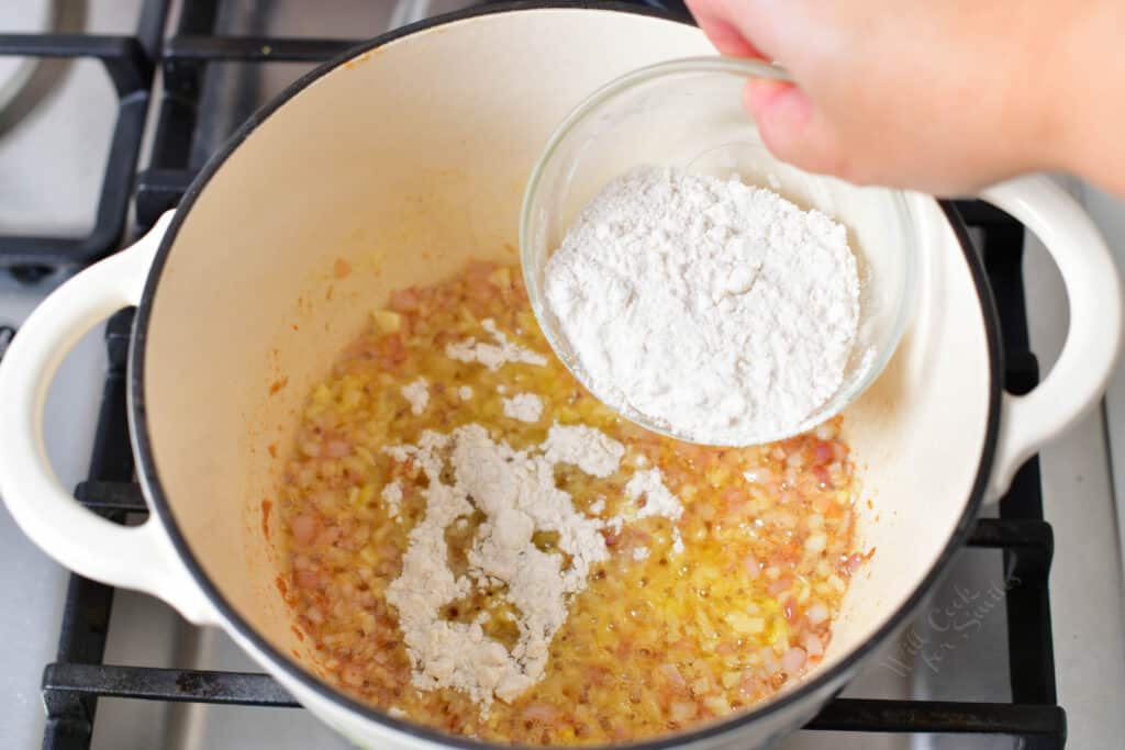 adding four over the onion in the pot