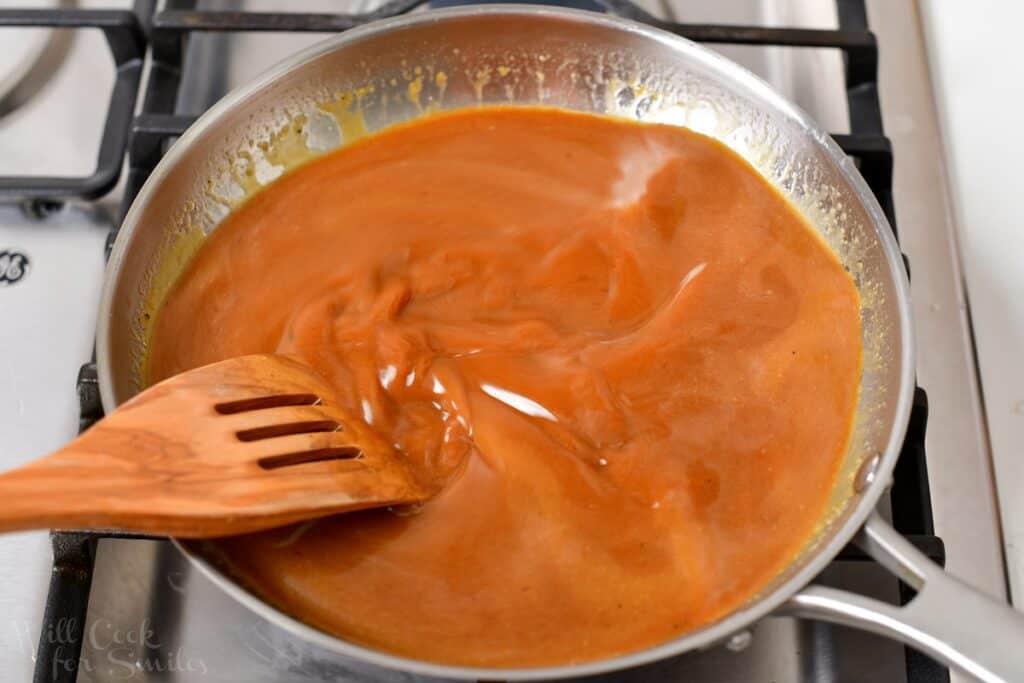 stirring gravy with a wooden spatula